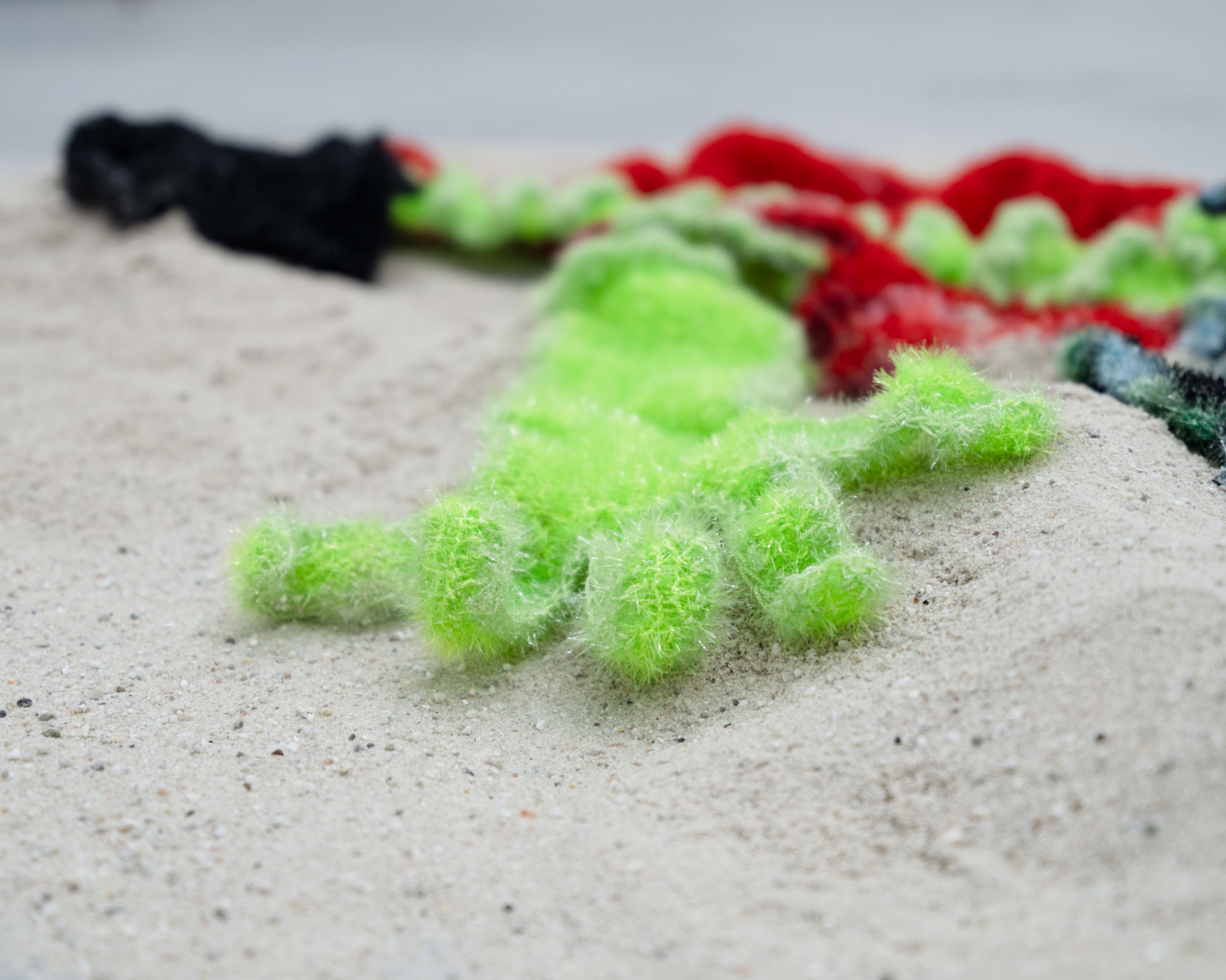 Green polyester yarn form on sand
