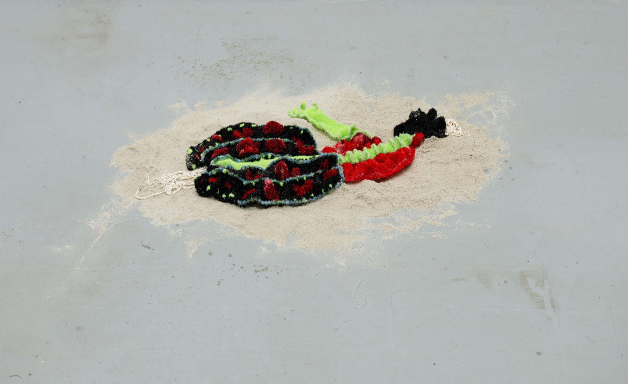 Greater Than Zero, a textile work arranged on sand