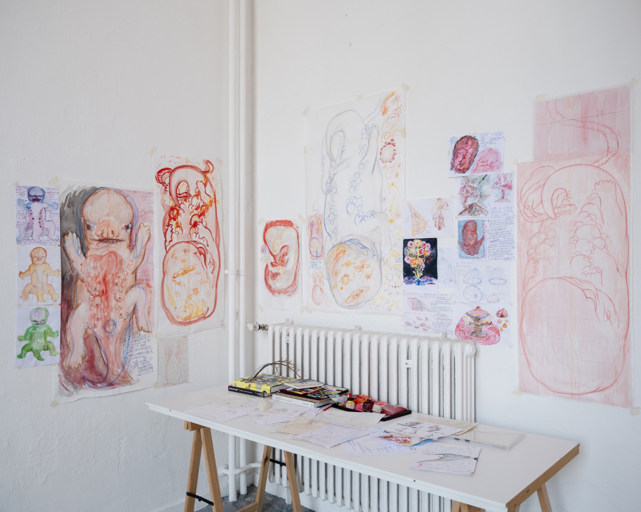 Sketches and research for Six Weeks displayed across a studio wall